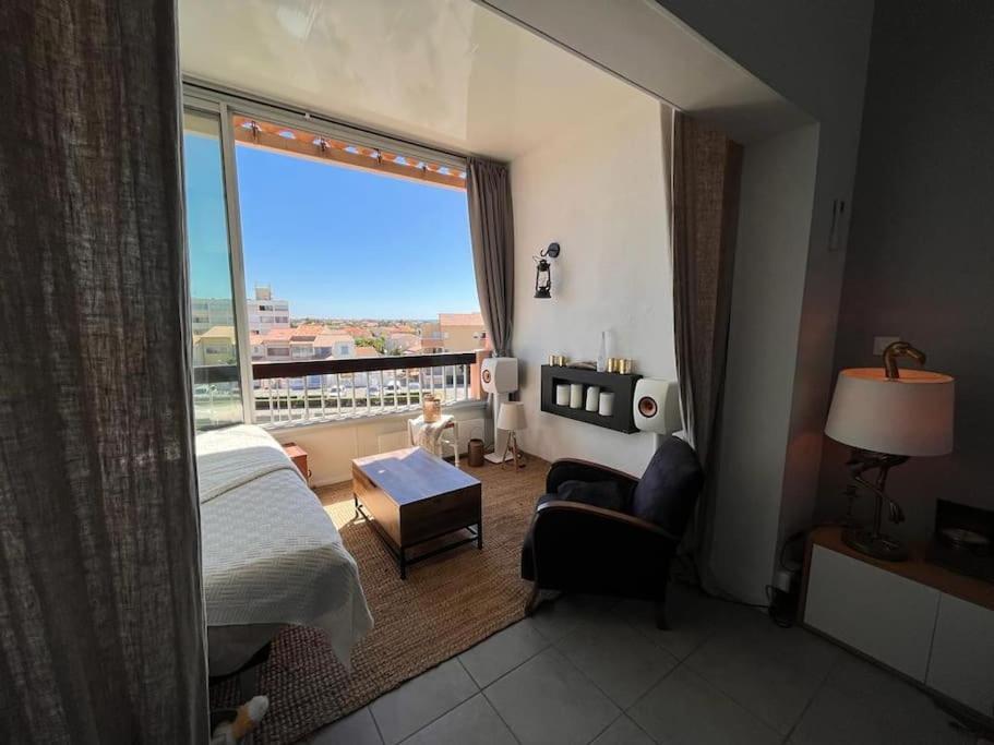 a room with a bed and a window with a view at Charmant duplex vue mer et étangs ! Clim / Parking in Frontignan