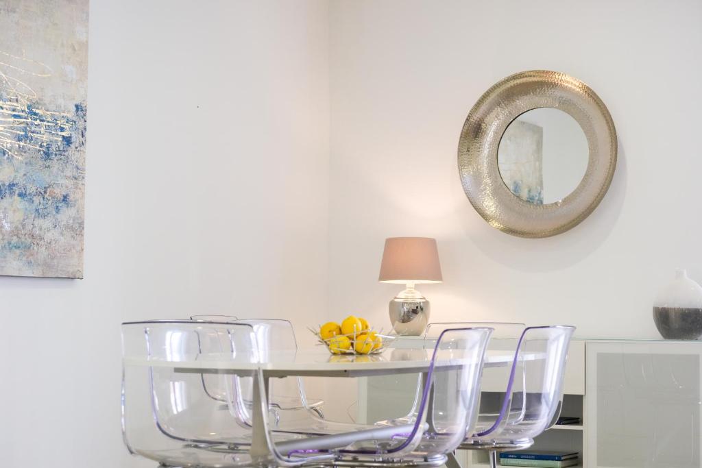 a dining room table with chairs and a mirror at 21 Townhouse in St Julians in Paceville
