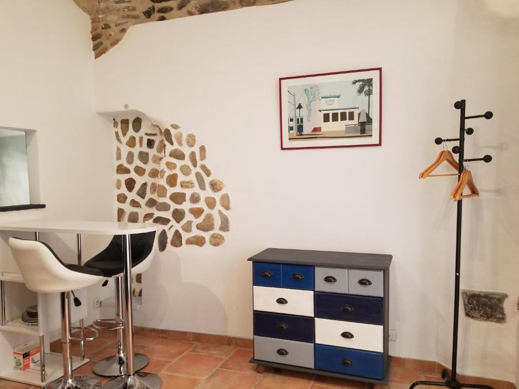 Zimmer mit einem Schreibtisch, einem Tisch und einer Kommode in der Unterkunft La chocolaterie in Anduze