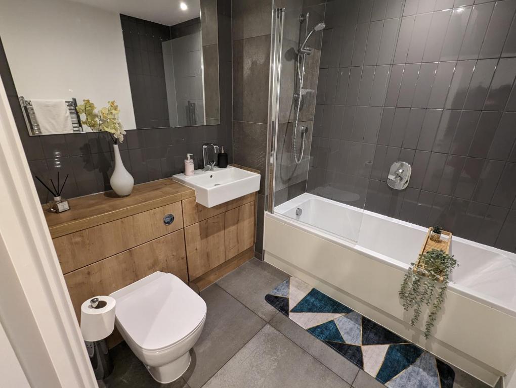 a bathroom with a toilet and a tub and a sink at Kingwood apartaments in London