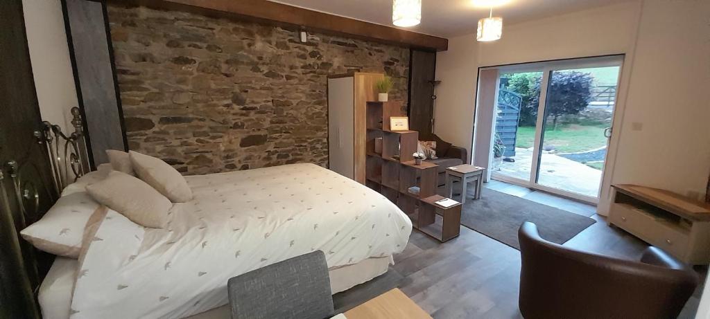 a bedroom with a bed and a stone wall at Wisteria Barn, Trewethen, Nr Port Isaac in Port Isaac