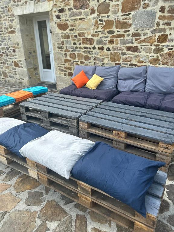 a group of benches with pillows on top of them at Les Ecuries in Saint-Maurice-en-Cotentin
