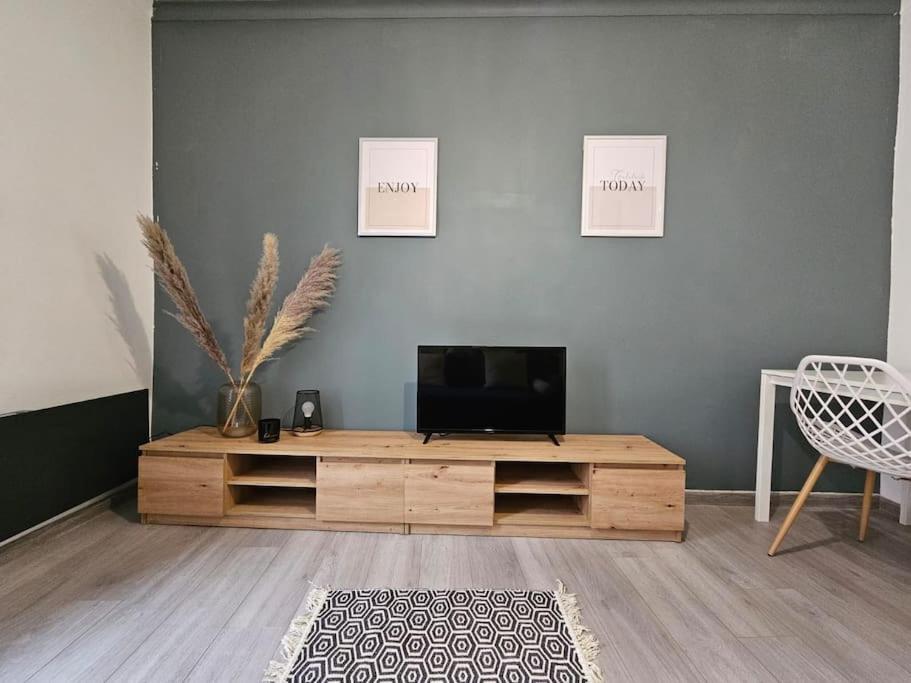 - un salon avec une télévision et un centre de divertissement en bois dans l'établissement Atlas - Era, à Béziers