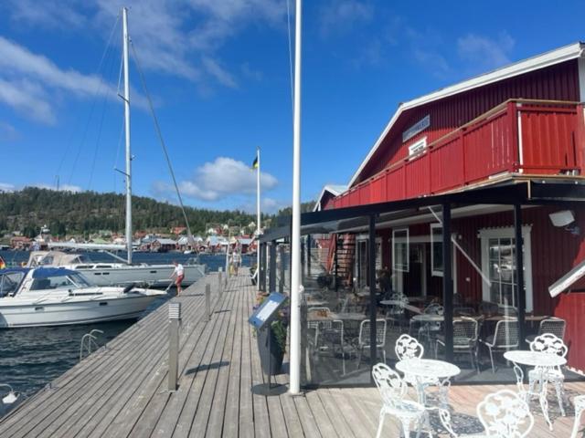 a dock with tables and chairs and a marina with a boat at Ulvö Hamnkrog in Ulvöhamn