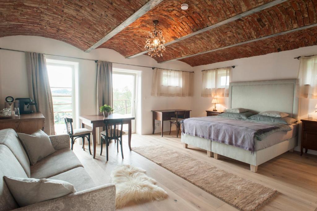 een slaapkamer met een bed, een bank en een tafel bij Am Pfarrhof - Gourmethotel by Harald Irka in Sankt Andrä-Höch