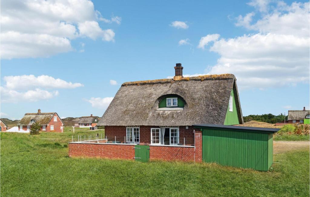 an old house with a thatched roof in a field at Gorgeous Home In Fan With Kitchen in Sønderho