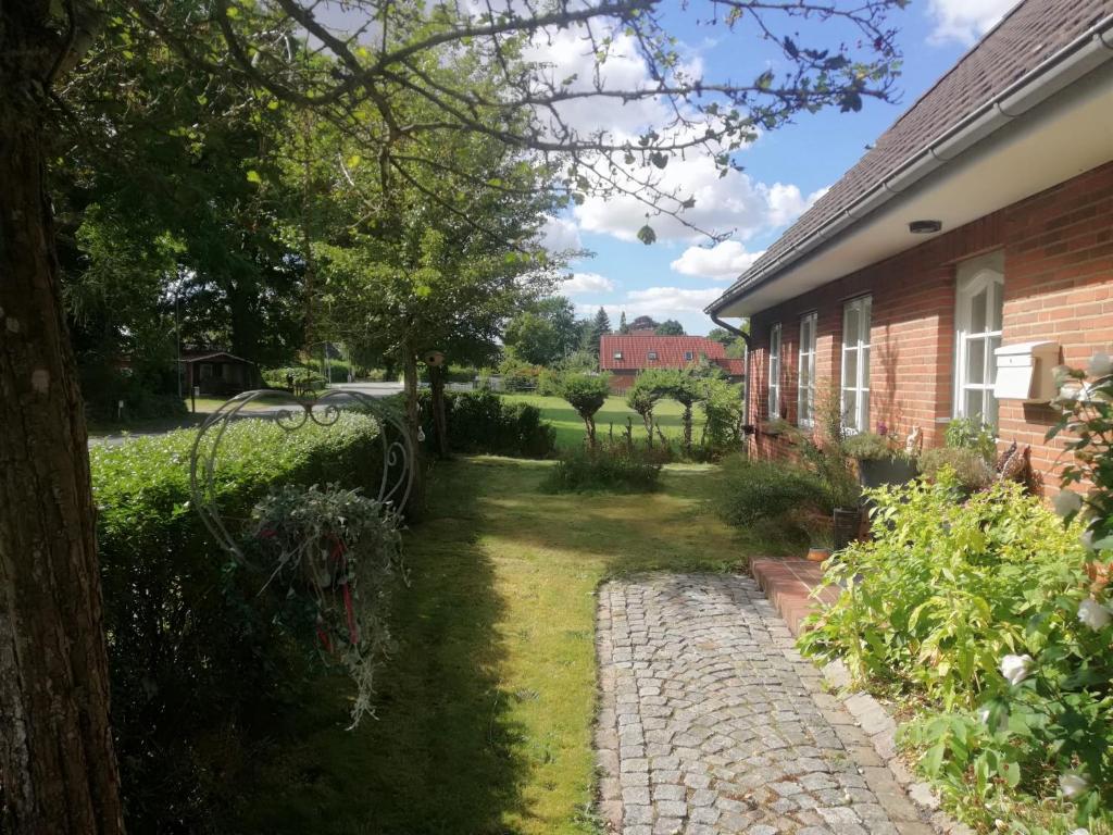 a house with a brick walkway next to a yard at Landhaus Braderup in Braderup