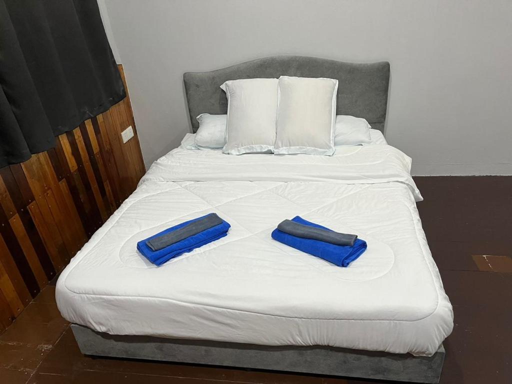 喬治市的住宿－sungai ujong home stay，床上有两条蓝色的毛巾