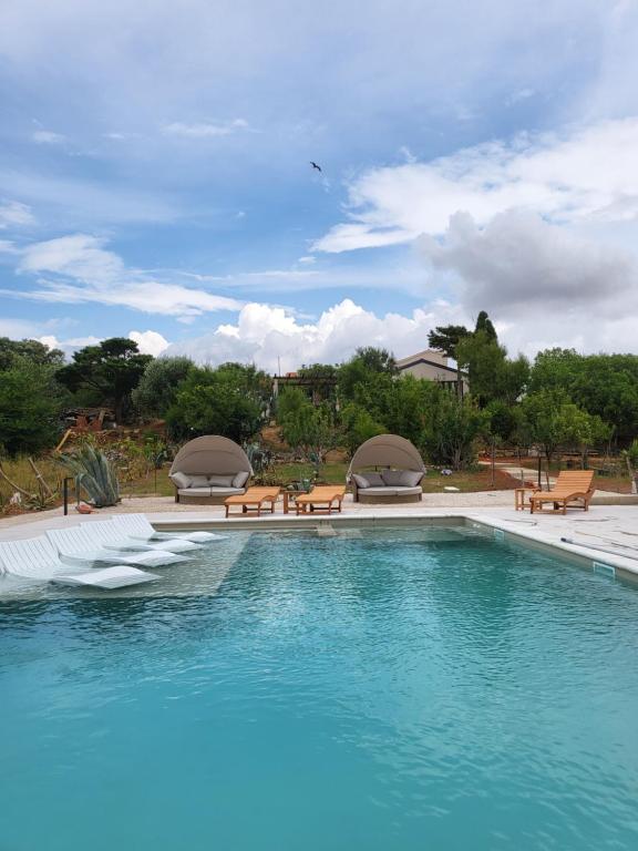 einen Pool mit blauem Wasser sowie Tischen und Bänken in der Unterkunft Villa Slatina near Zrce beach in Novalja