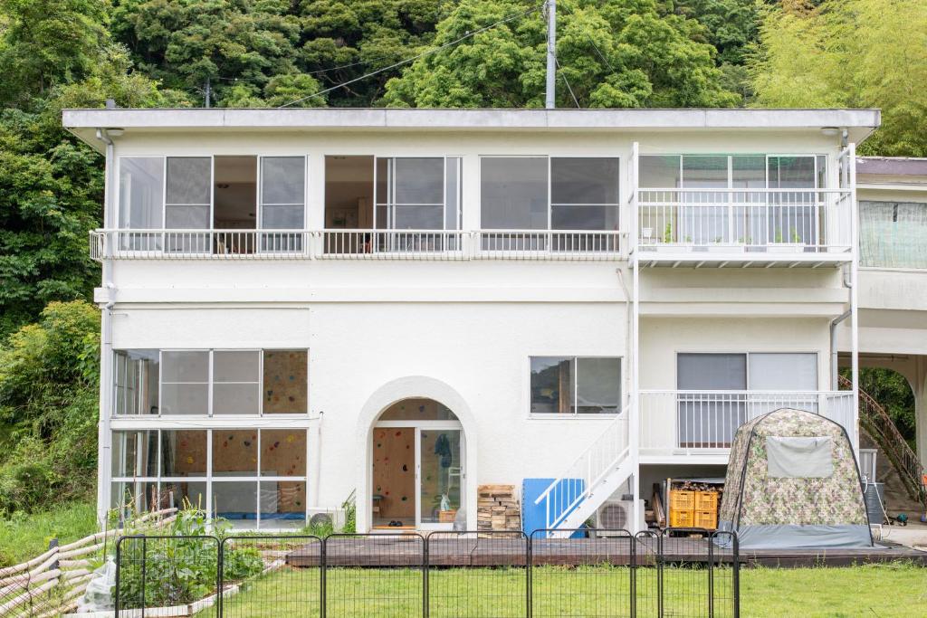 a white house with a fence in front of it at 南伊豆　貸別荘　夜空の星 in Minamiizu