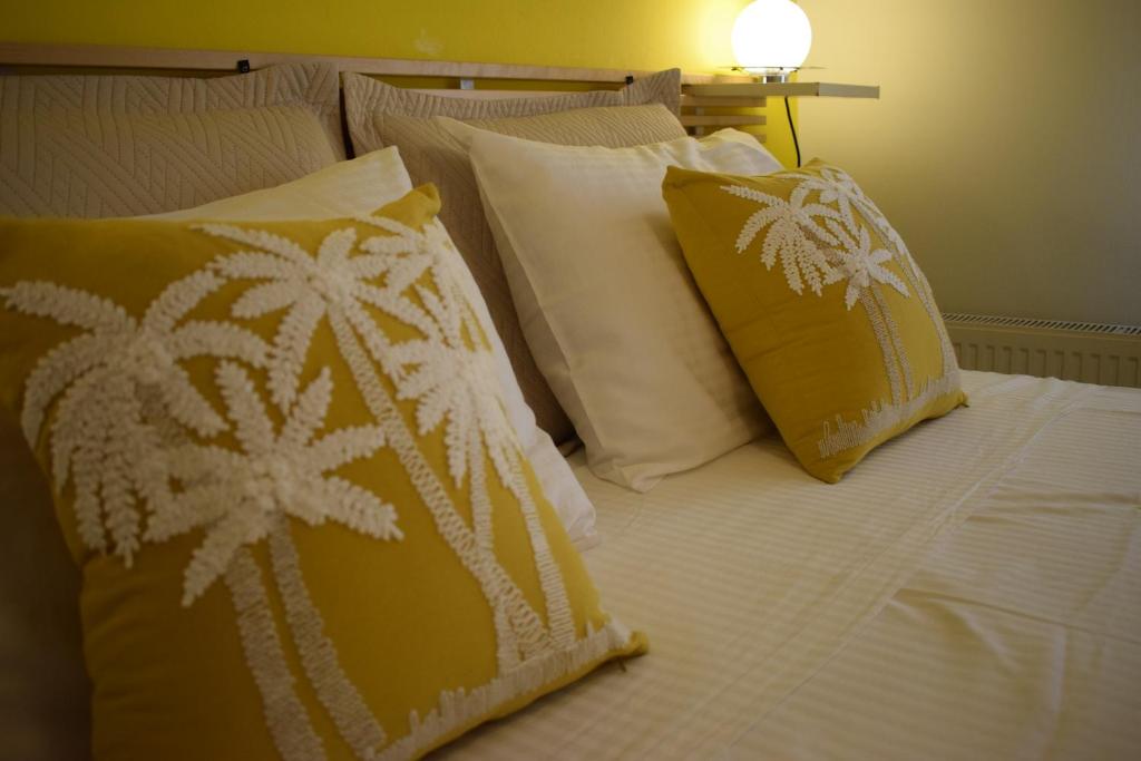 a bed with yellow and white pillows on it at Ilian Studios in Parga