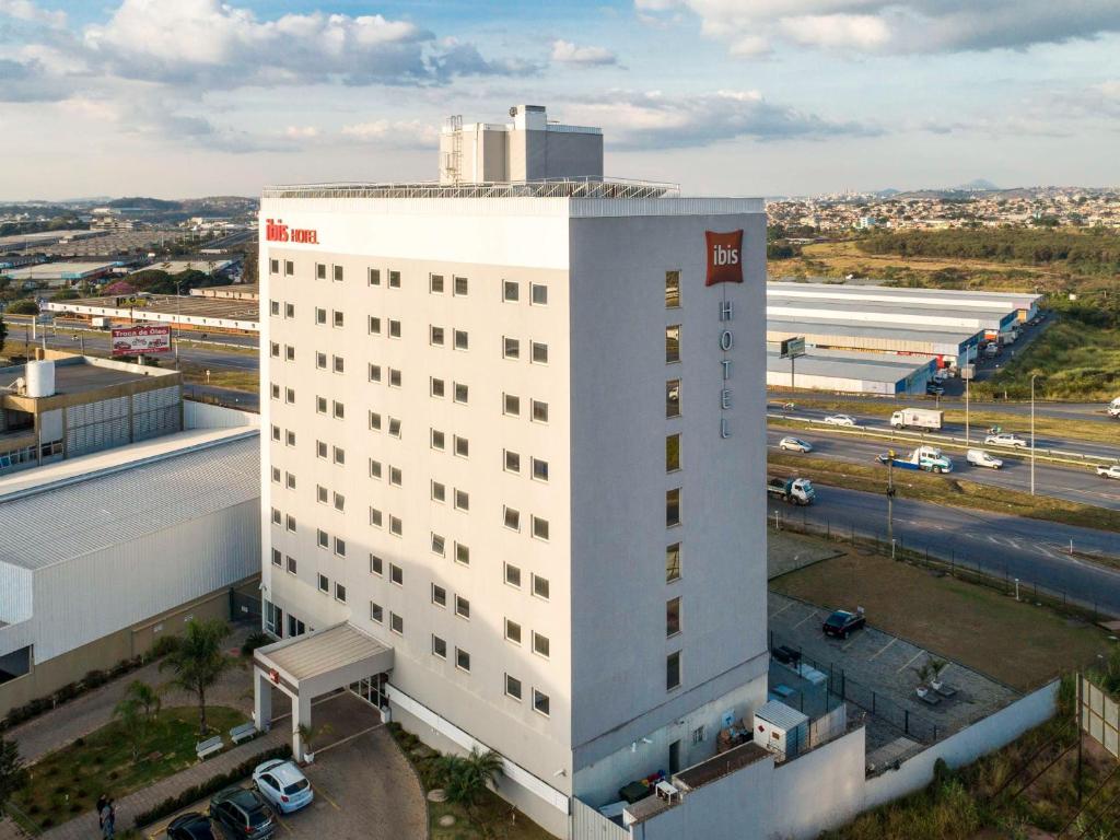 an aerial view of a white building with a parking lot at ibis Contagem Ceasa in Contagem