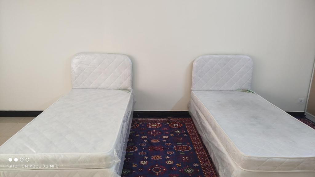 two beds sitting next to each other in a room at Lady's bedspace in Dubai