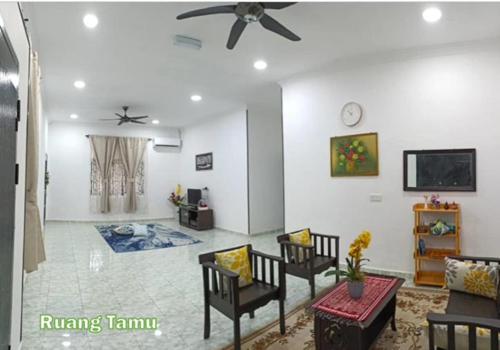 a living room with chairs and a ceiling fan at Kampung Vibe @ Homestay Baiduri in Slim River