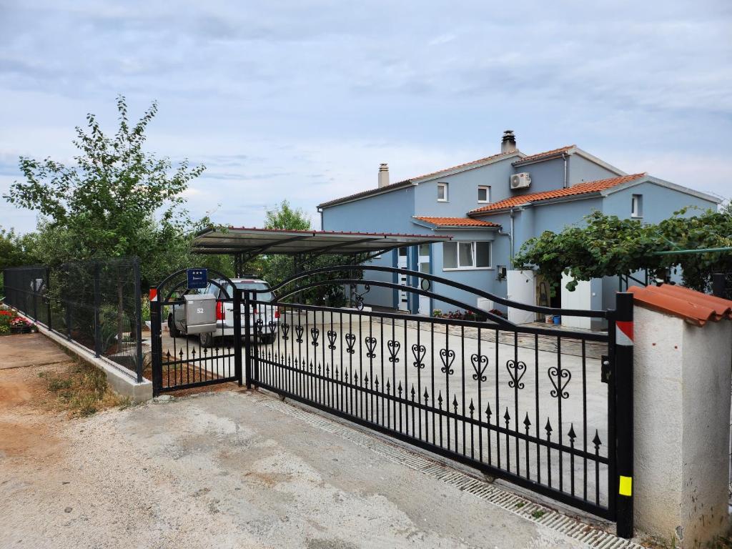 Ein schwarzer Zaun vor einem Haus in der Unterkunft Apartman Emir in Marčana