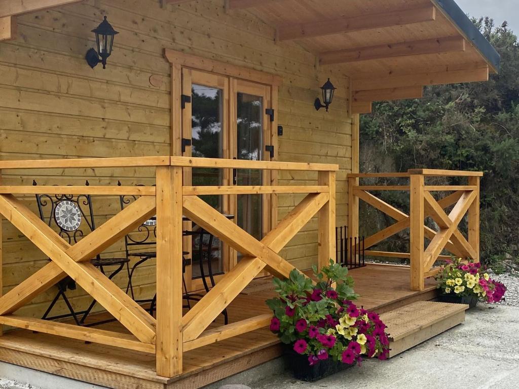 a wooden cabin with a porch and a deck at Cabin 438 - Clifden in Clifden