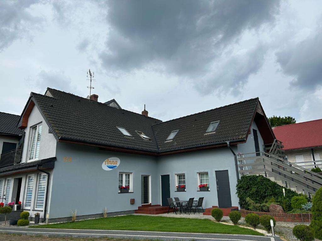 a white house with a black roof at DOM GOŚCINNY ANNA in Niechorze