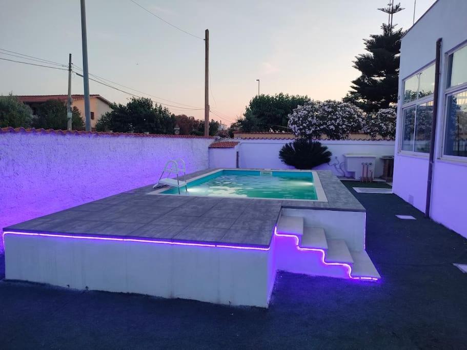 a swimming pool with purple lights next to a building at Alloggio turistico 7 min dall'Aeroporto in Focene