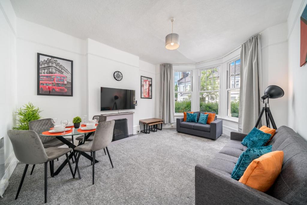 a living room with a couch and a table at Spacious king size 1bed flat in leafy suburb in London