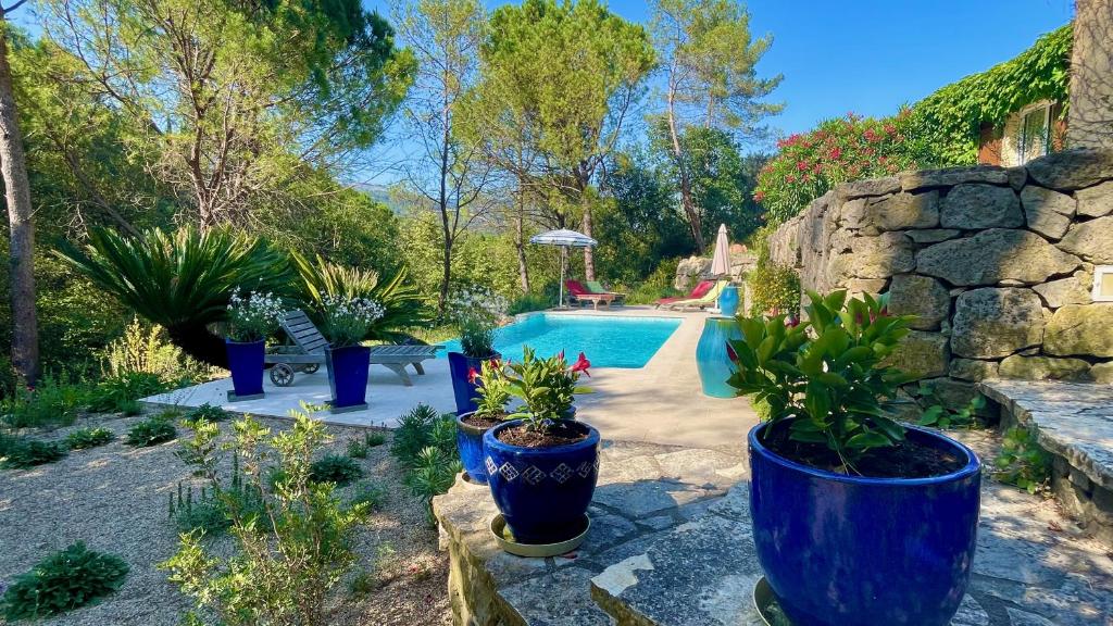 una piscina con macetas en un patio en Azur Blue Villa; Rural Peace with private pool, en Peymeinade