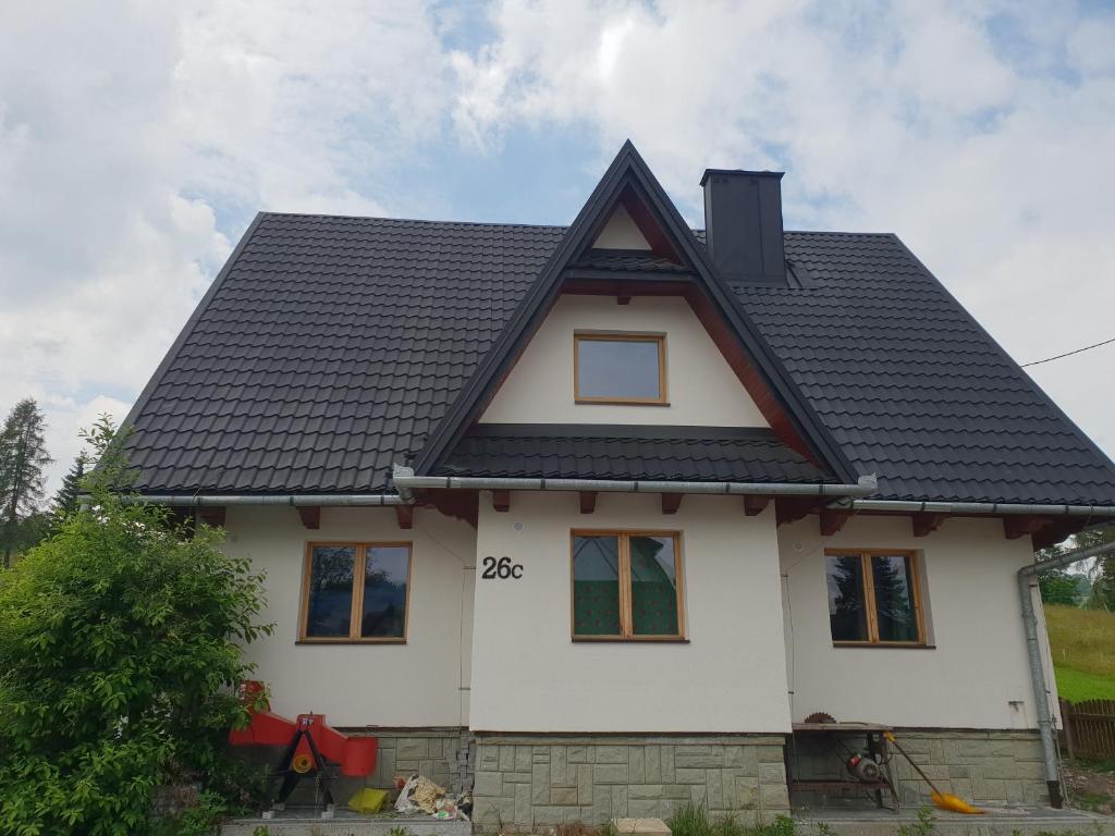 a white house with a black roof at Chochołowsko-Witowski Wypoczynek in Witów