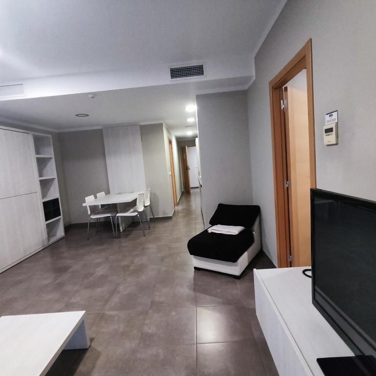 a living room with a couch and a television at Aparthotel Meseguer in Alcañiz