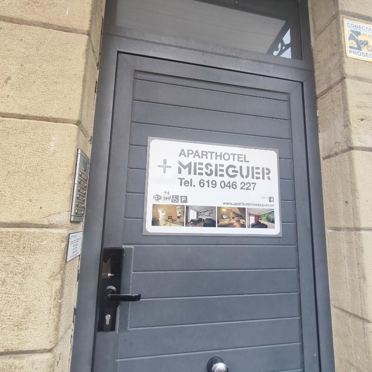 a blue door with a sign on top of it at Aparthotel Meseguer in Alcañiz