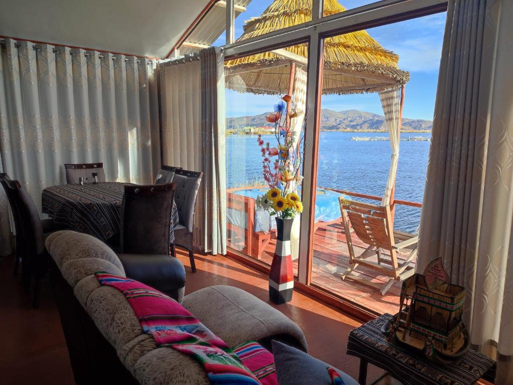 a living room with a couch and a view of the ocean at TITICACA JALTAWI LODGE in Puno