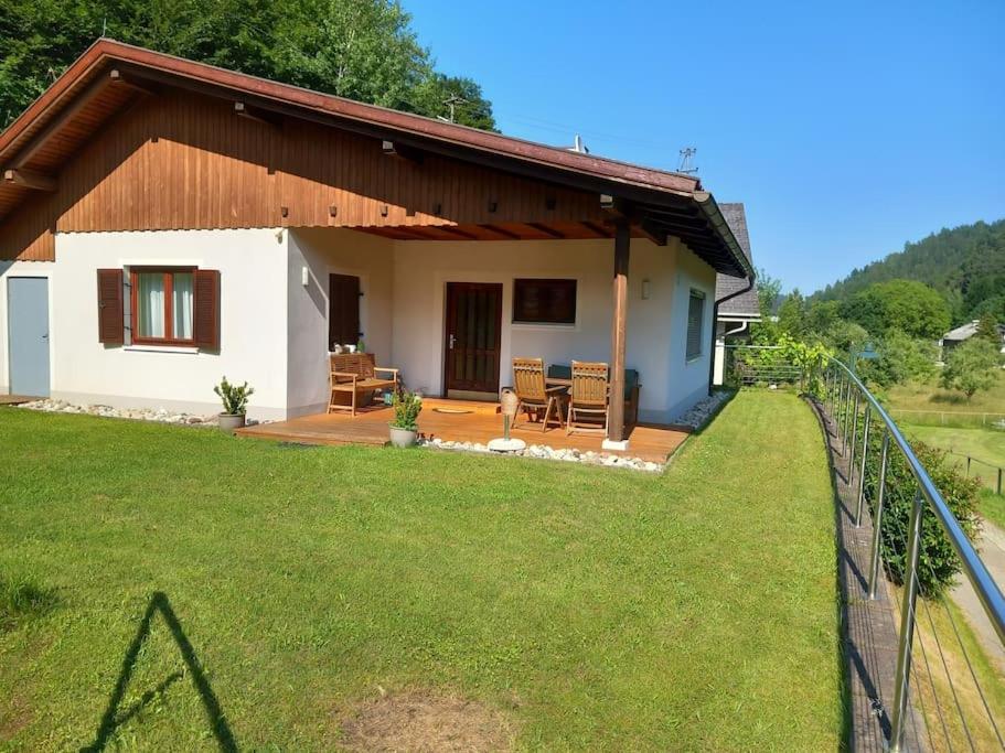 una pequeña casa con un césped verde delante de ella en Ferienhaus, en Maria Wörth