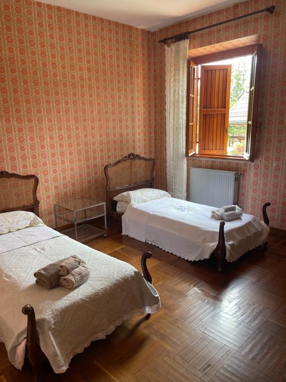 a bedroom with two beds and a window at Villa prestigiosa ampie metrature in Altipiani di Arcinazzo