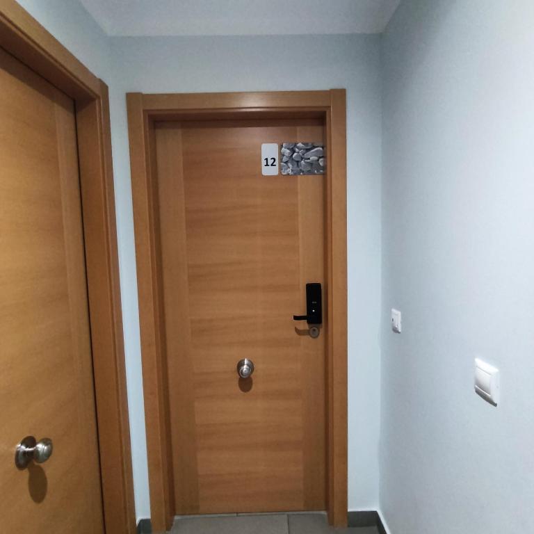 a wooden door with a sign on it in a room at Aparthotel Meseguer in Alcañiz