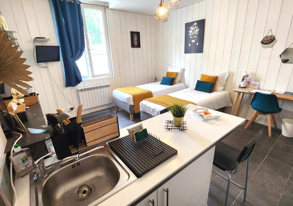 una cocina con fregadero y una habitación con 2 camas en "Le Studio" Les Halles - Tout Confort - Parking - Arrivée Autonome, en Tours