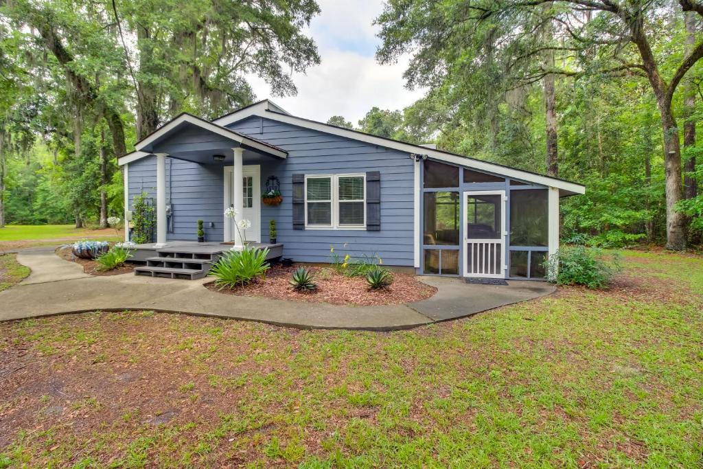 a blue tiny house in the woods at Bright Guyton Home with Private Yard and Hot Tub! in Port Wentworth