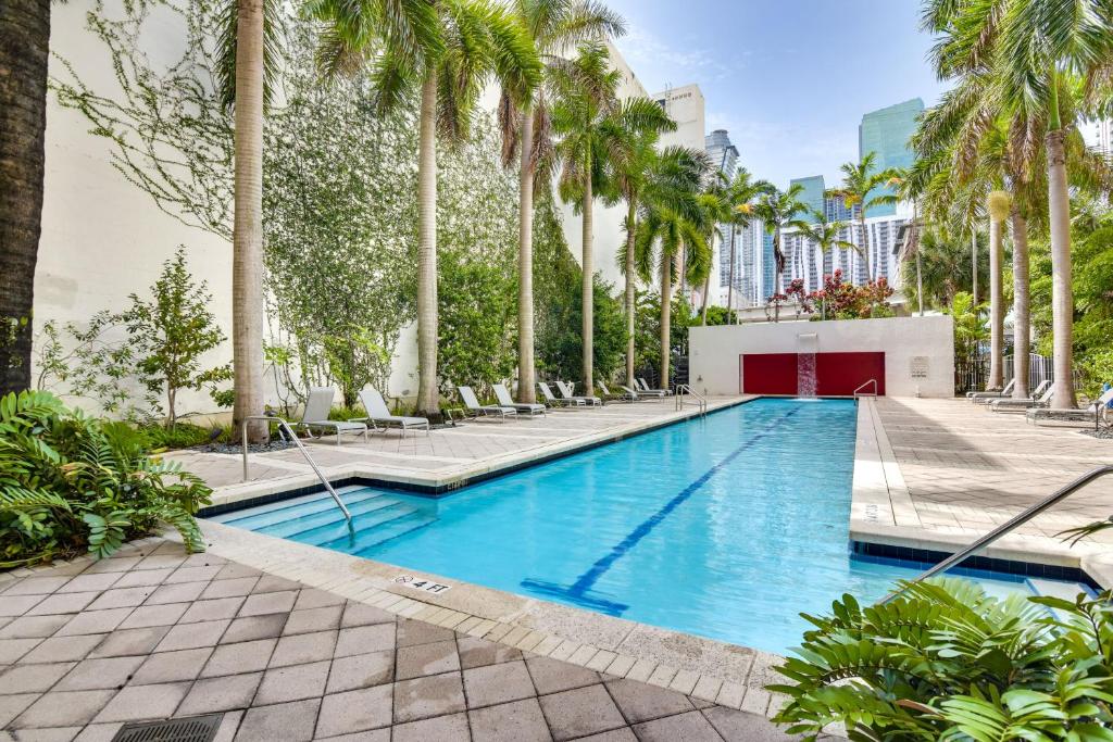 une piscine avec des palmiers dans un complexe hôtelier dans l'établissement Trendy Downtown Miami Studio Pools, Views and More!, à Miami
