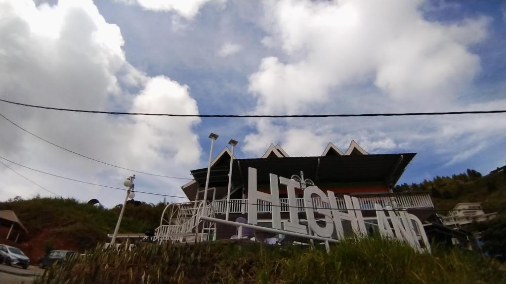 a building with a sign on the side of it at Highland Homestay Kundasang in Ranau