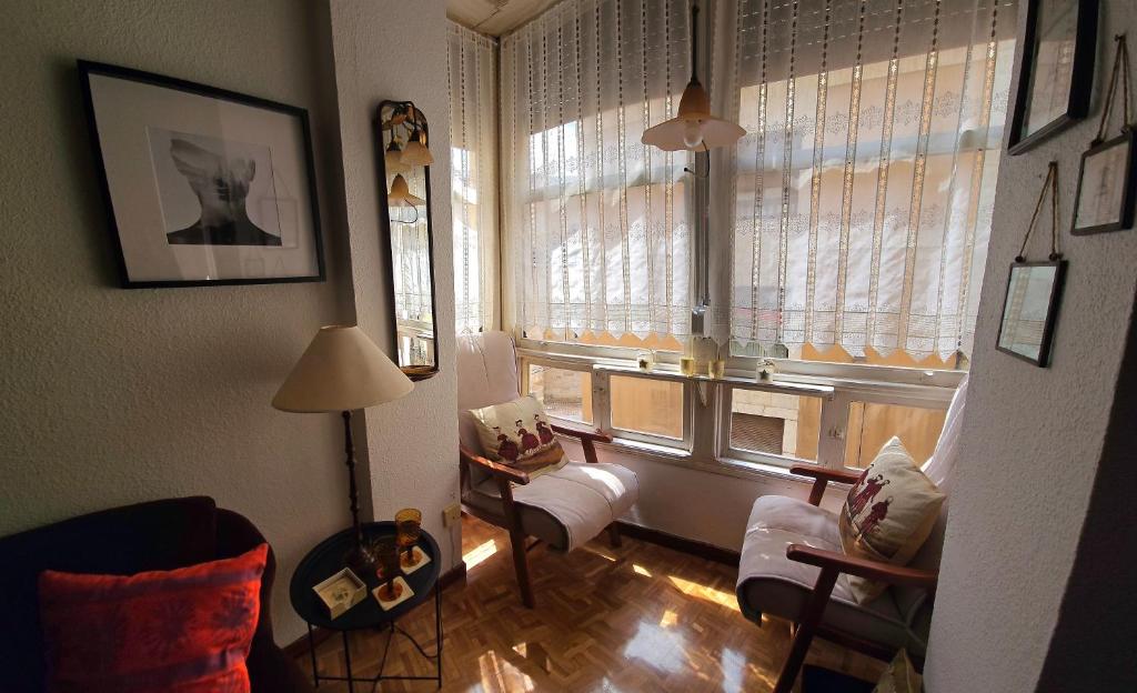 uma sala de estar com uma grande janela com cortinas em La casa del mirador em Zamora