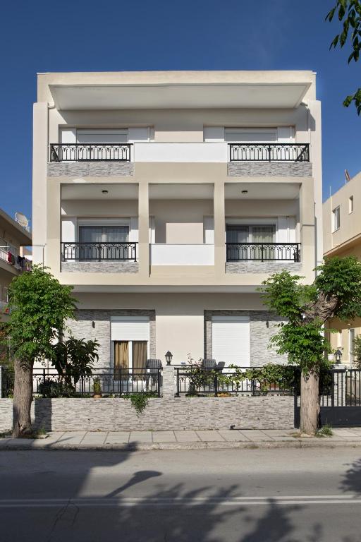 a large white building with tables in front of it at Kostas 2 in Kos