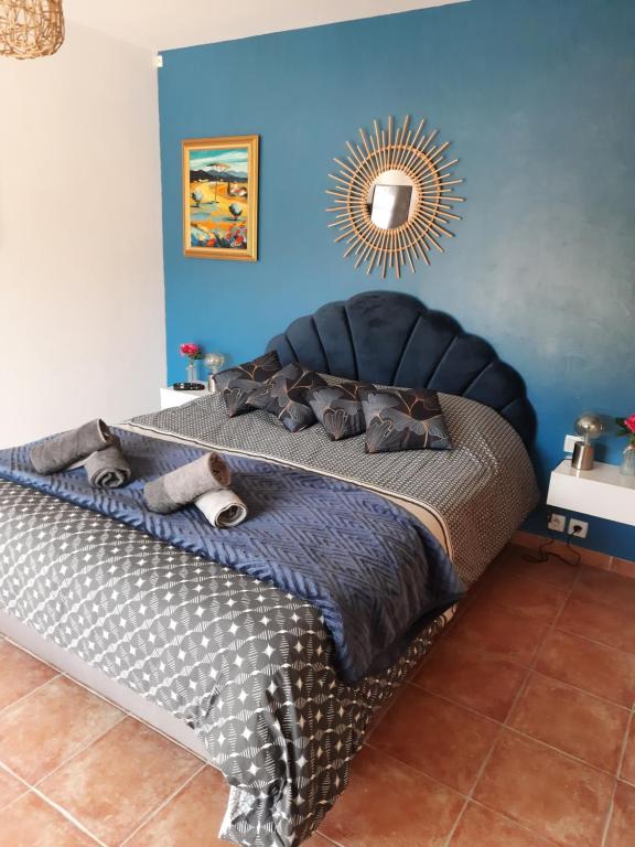 1 dormitorio con 1 cama grande y pared azul en Le petit ribbas, en Le Cannet-des-Maures