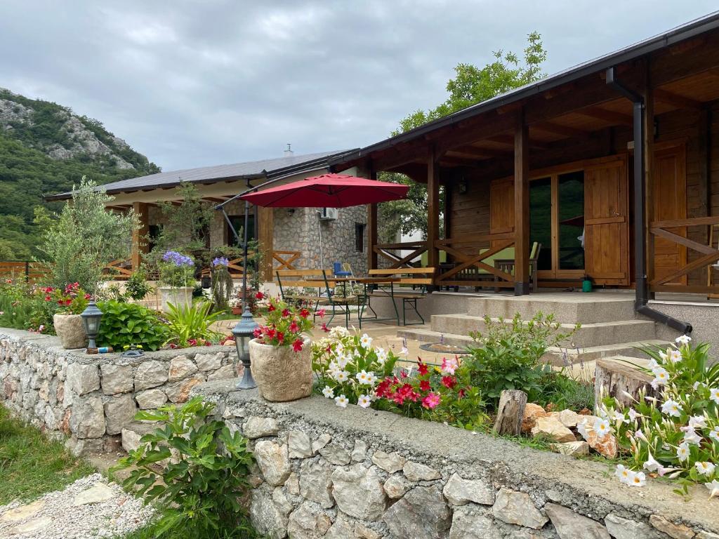 una casa con una pared de piedra y una sombrilla en Guest House Mare, en Bar