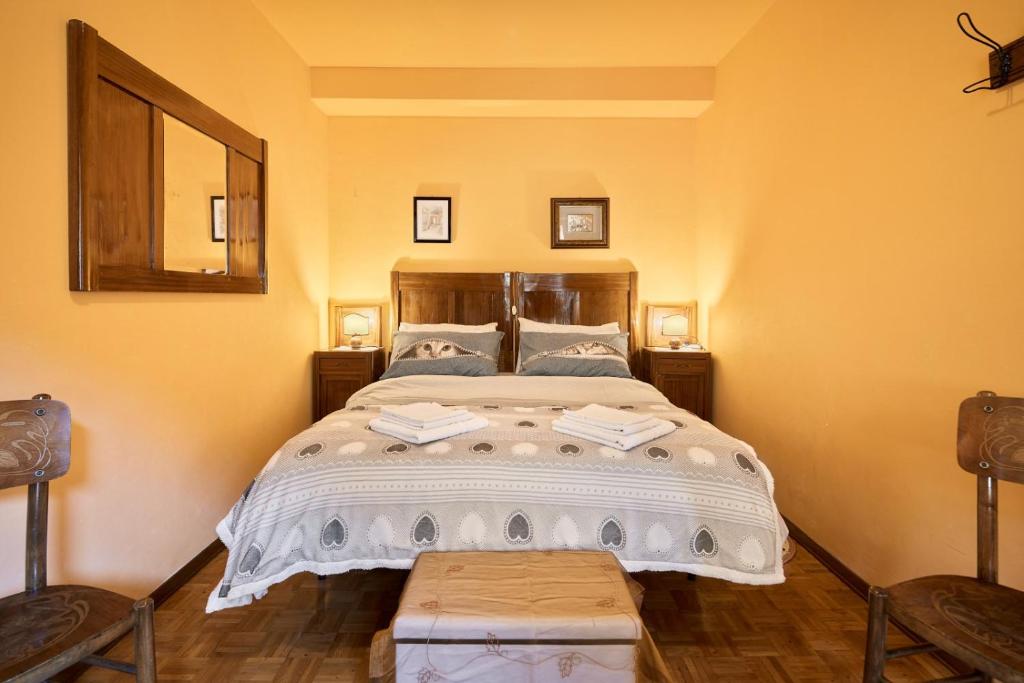 1 dormitorio con 1 cama grande y 2 sillas en Casa ai Lali, en Forno di Zoldo