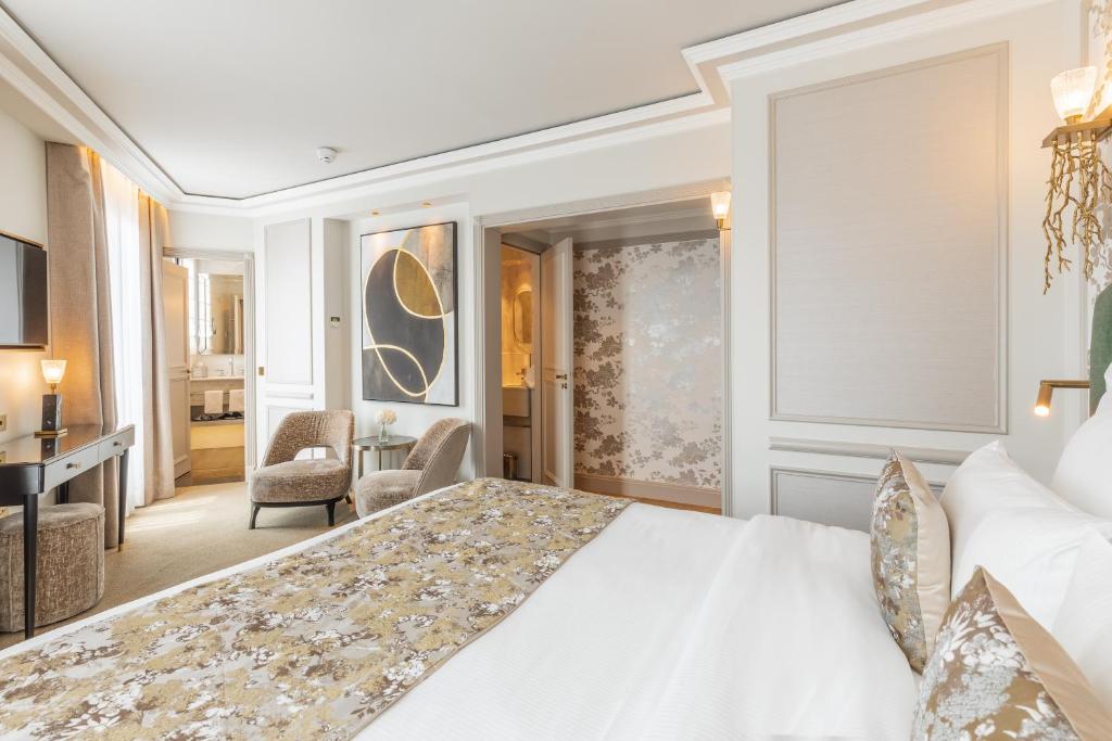 a bedroom with a large white bed and a living room at Manolita Paris in Paris