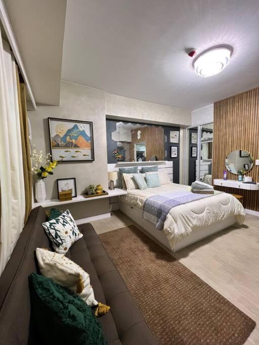 ein großes Schlafzimmer mit einem Bett und einem Sofa in der Unterkunft Luxury Suite in Araneta in Manila