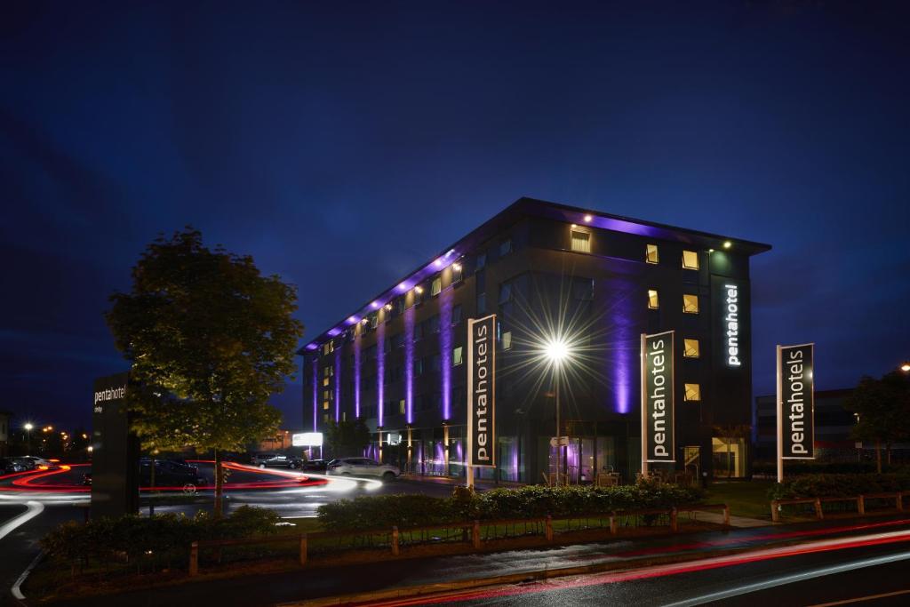 a city street at night with a large building at pentahotel Derby in Derby