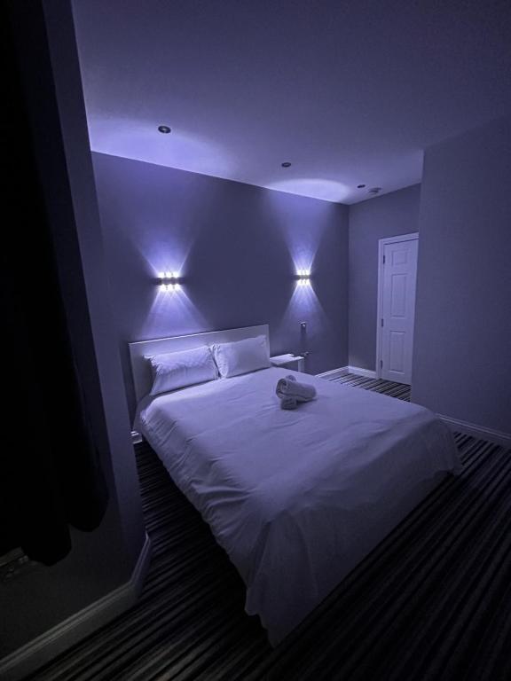 a bedroom with a white bed with lights on it at 339 High Town Road in Luton