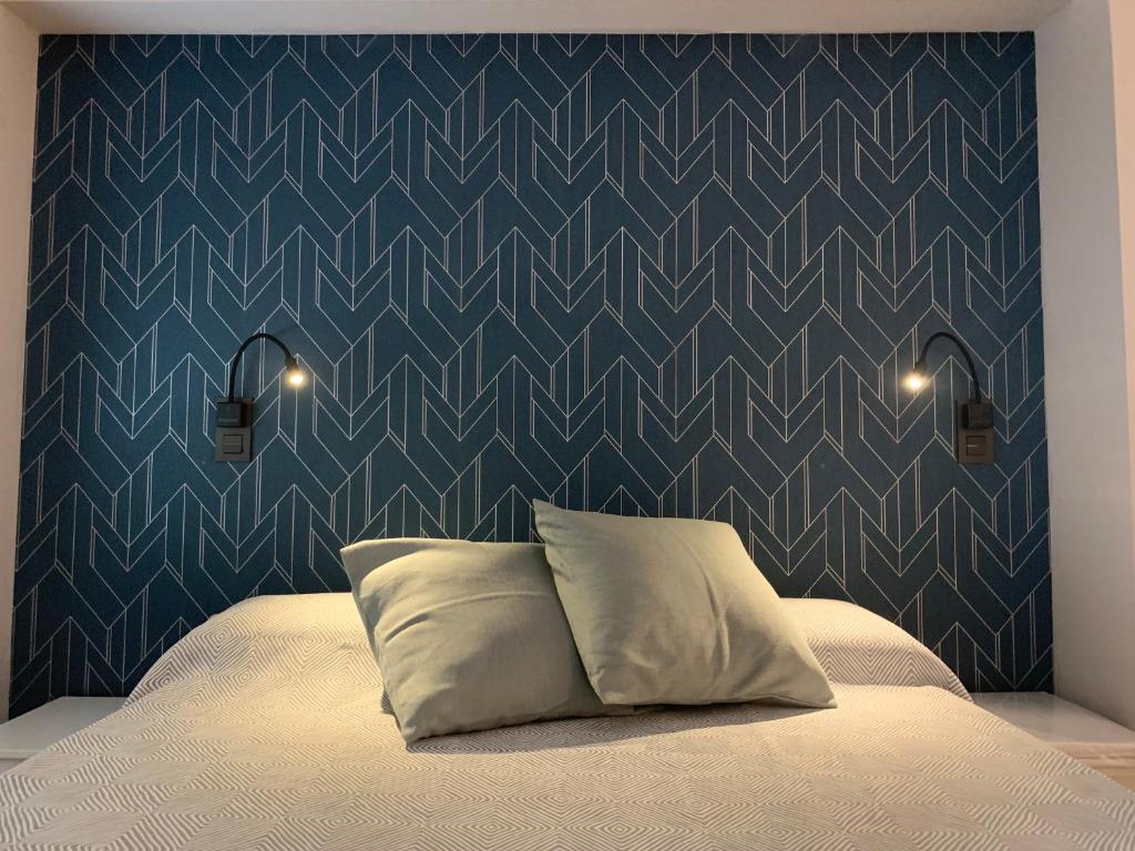 1 dormitorio con 1 cama con pared azul en Espectacular loft lleno de luz y espacio! en Zaragoza