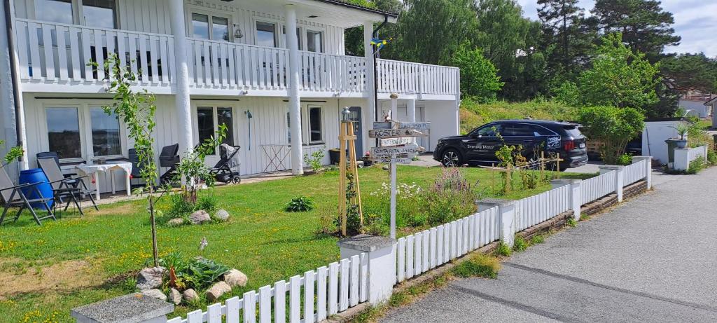 una casa con una valla blanca y un coche aparcado en el patio en Bentevägen, en Strömstad