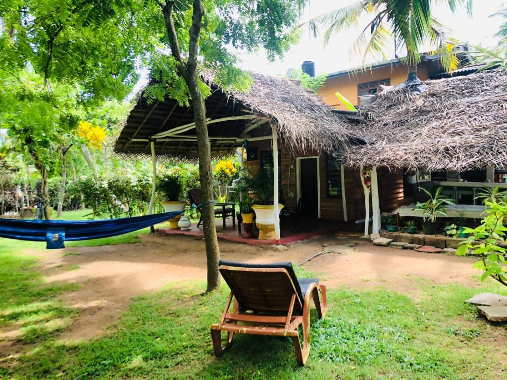 a hammock in front of a house at Lake view cabana Paradise & Villa in Tangalle