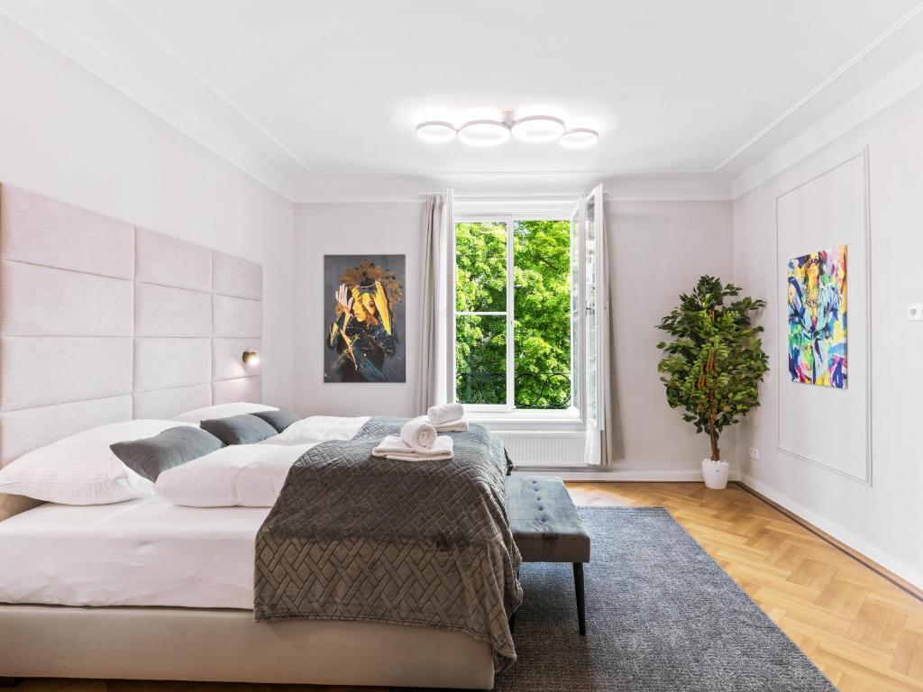 a white bedroom with a large bed and a window at SKY9 Apartments Schönbrunn Palace in Vienna