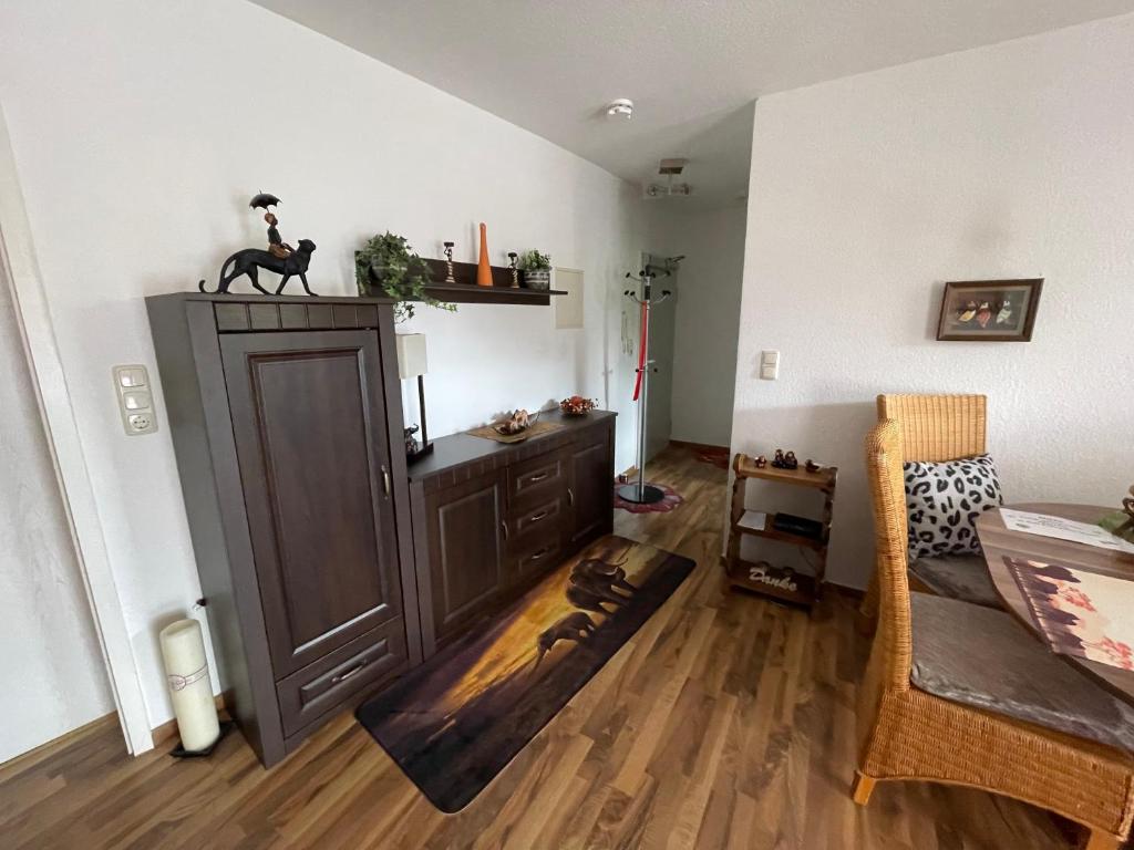 una sala de estar con un gran armario marrón y suelos de madera. en Möblierte Wohnung für Geschäftsreisen/Ferienwohnung Plauen Stadtmitte, en Plauen