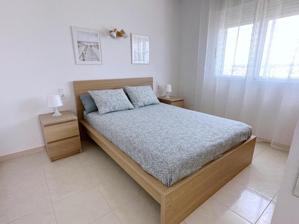 um quarto com uma cama e uma janela em AT-Pineda-03 em La Pineda